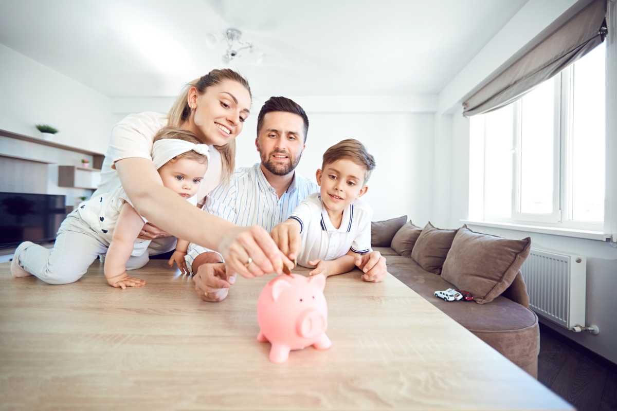 A smiling family saves money with a piggy bank
