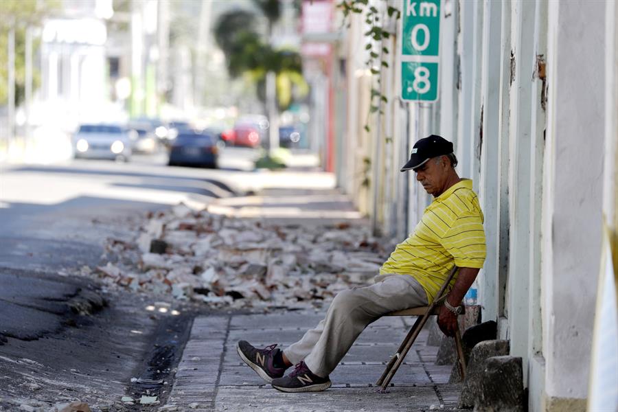 Un hombre descansa este martes cerca a unas casas derrumbadas por la fuerza dado el sismo de magnitud 6,4 en Yauco (Puerto Rico). EFE/Thais Llorca