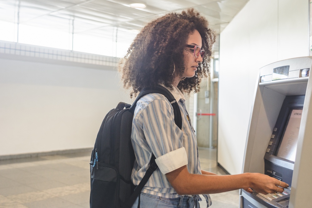 Young woman withdrawing money at the ATM