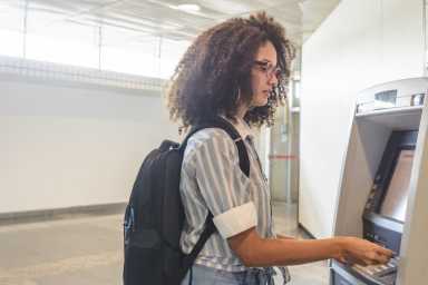 Young woman withdrawing money at the ATM